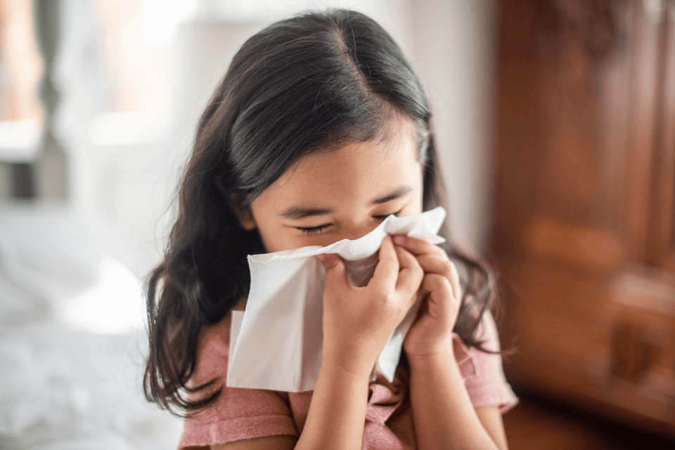 kid trying to stop nose bleed with tissue