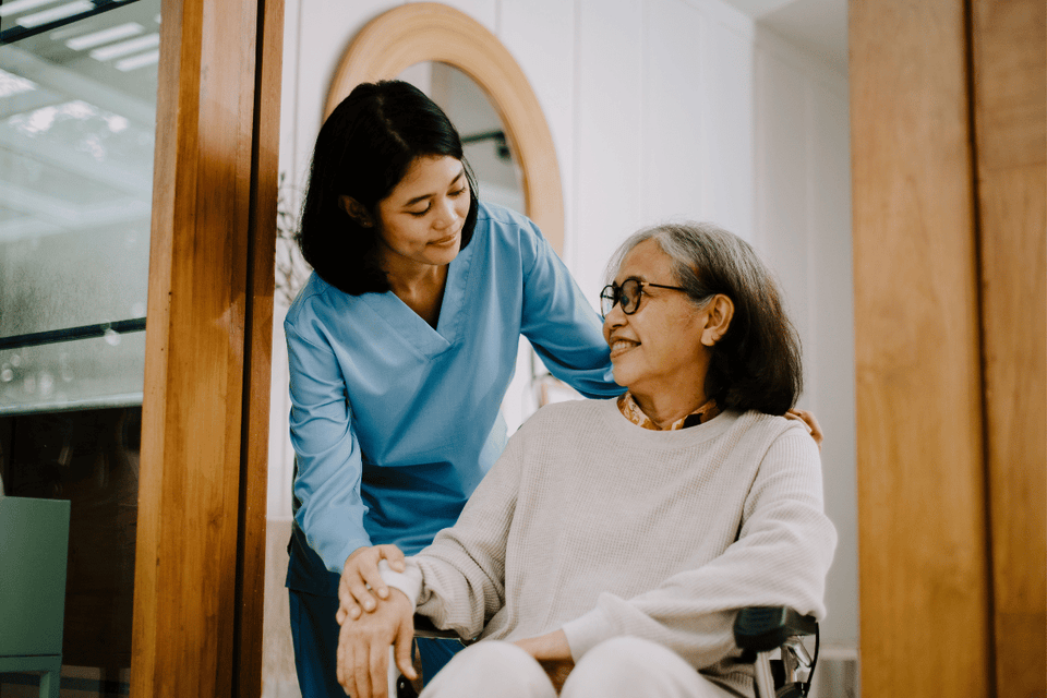 caregiver helping woman after Mohs procedure to change dressings
